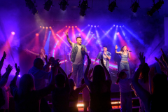 Nightclub action shot of lead singer and backing vocalists